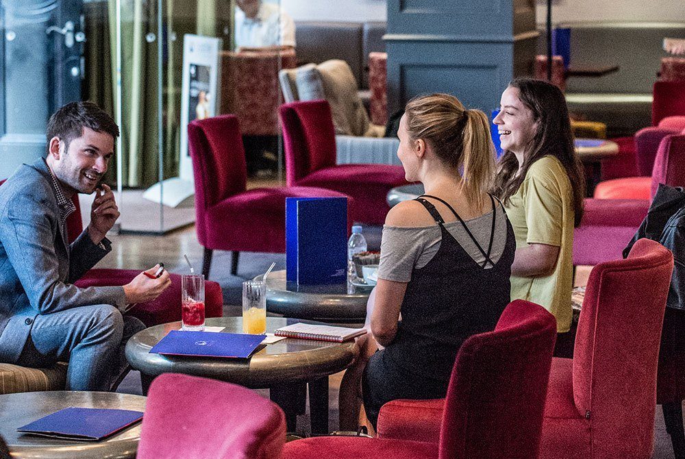 Friends sitting down in the hotel's comfortable bar and chatting
