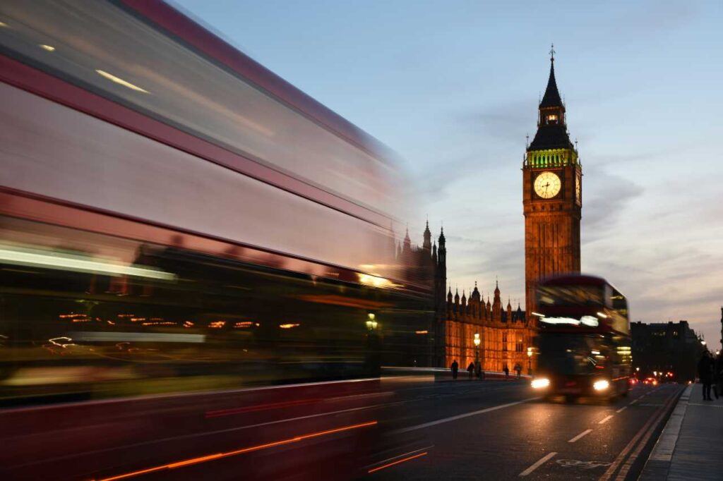 concerts in london this summer - london night bus moving past houses of parliament and big ben
